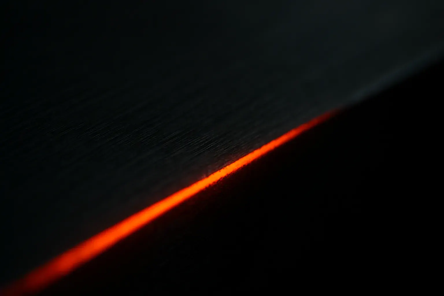 An abstract, glowing texture of worked metal in warm orange against near-black — the studio’s signature visual motif.